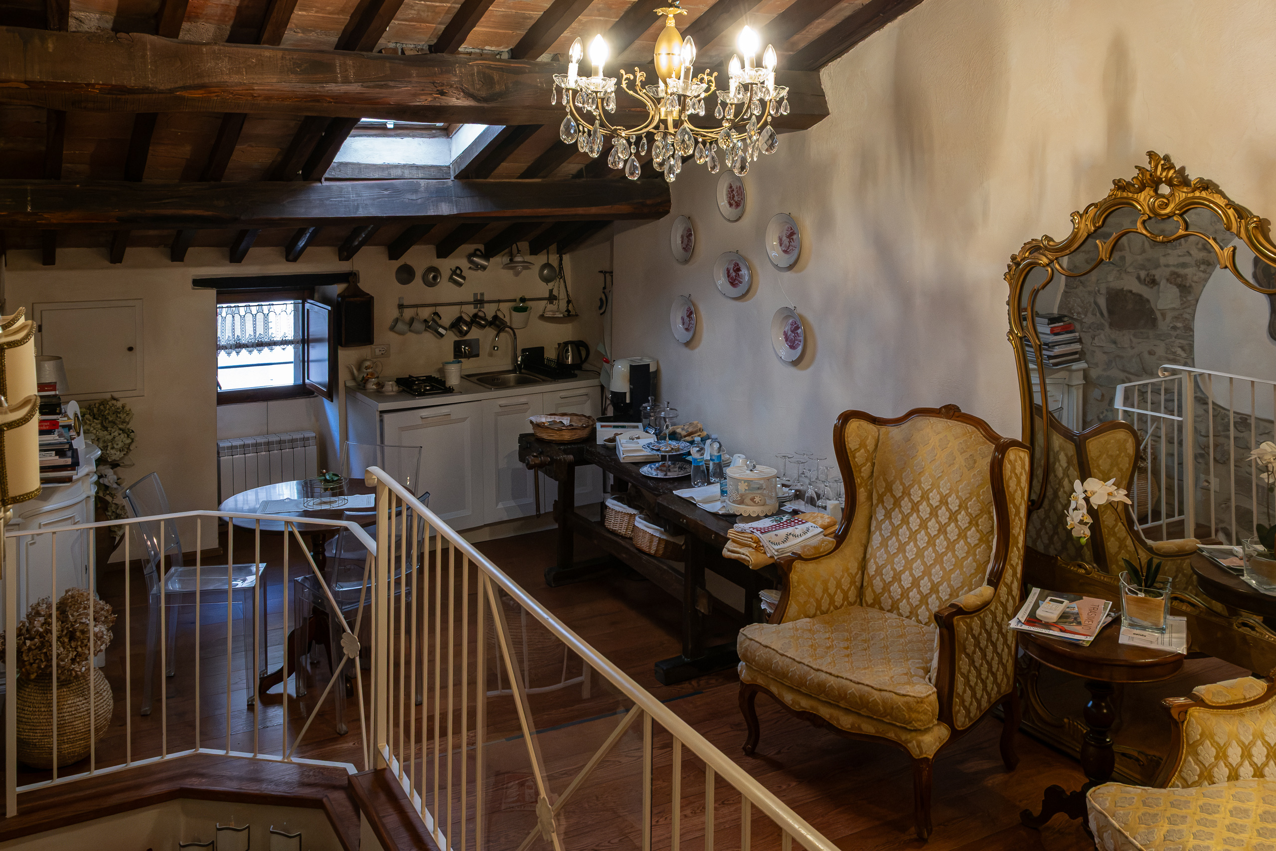 Im Apartment – Kronleuchter, Ohrensessel und Holzbalken